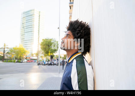 Legerer Mann gegen eine Wand in der Stadt, Barcelona, Spanien schiefen Stockfoto