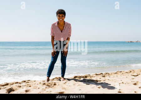 Frau am Strand mit Blick auf die Kamera Stockfoto