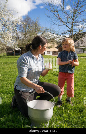 Mutter und Tochter mit frischer Milch in einem Eimer auf der Weide Stockfoto