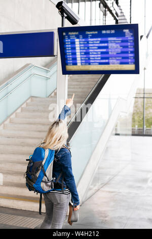 Frau Kontrolle der Anzeigetafel an der Station Stockfoto