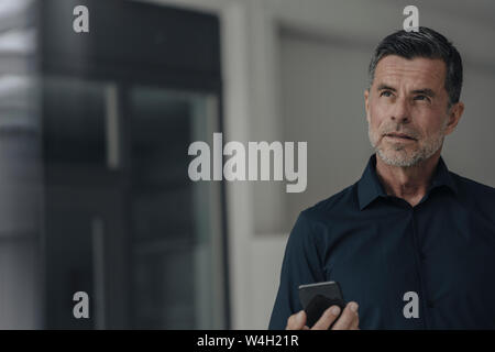 Portrait von schweren Reifen Geschäftsmann mit Mobiltelefon Stockfoto