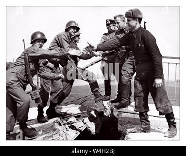 TORGAU Ost trifft West WW2-Bild von US-amerikanischen und sowjetischen Truppen treffen auf der Brücke über die Elbe bei Torgau am 26. April 1945. Die berühmten "Handshake von Torgau" fotografieren, Ost West nahe dem Ende des Zweiten Weltkrieges U S Erste Armee bedeutete Kreuzung beschädigte Brücke über den Fluss Elbe Torgau Sachsen Deutschland U.S. Army photo Stockfoto