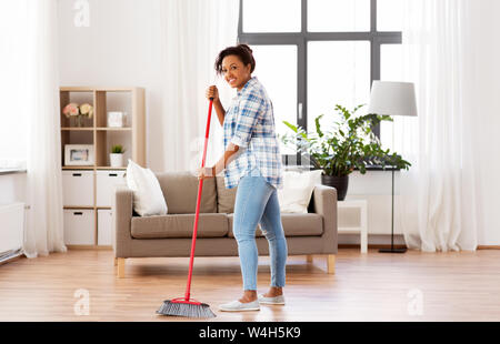 Frau mit Besen fegen Bürstenreinigung Boden Stockfoto