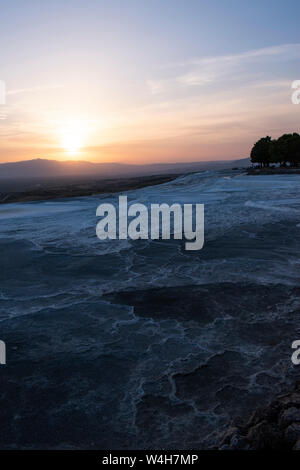 Türkei: Sonnenuntergang auf der Travertin Terrassen von Pamukkale (Baumwolle), natürlichen Standort Sedimentgestein durch Wasser aus den heißen Quellen hinterlegt, Stockfoto