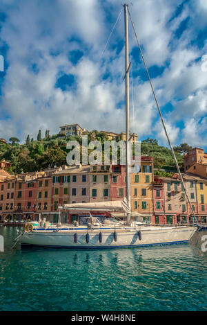 Luxusyacht vertäut im Hafen von Portofino, Italien an der italienischen Riviera mit bunten waterfront Gebäude hinter Stockfoto