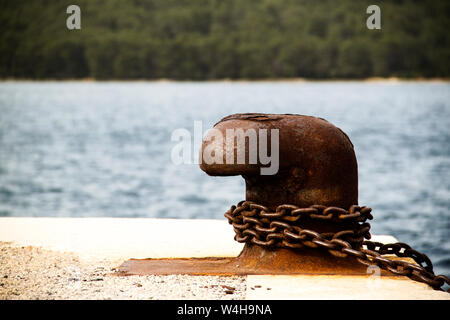 Alte und rostige Liegeplatz post auf konkrete Dock auf den Hafen Stockfoto