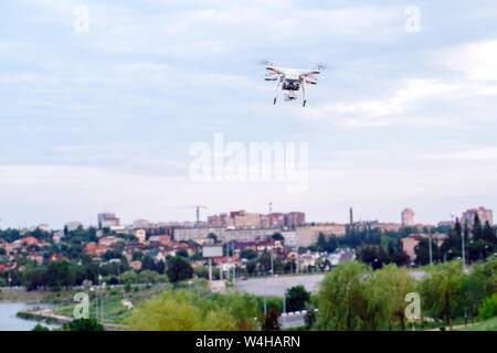 Drone quad Copter mit hochauflösenden Digitalkamera flying schwebt über der Stadt. Stockfoto