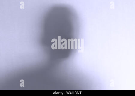 Beängstigend Ghost Face hinter einer weißen Glas Hintergrund verschwommen. Horizontale Ausrichtung Stockfoto