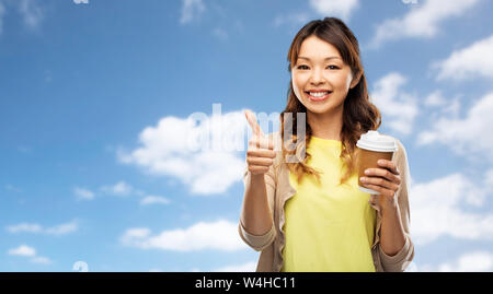 Asiatische Frau trinkt Kaffee und zeigen Daumen hoch Stockfoto