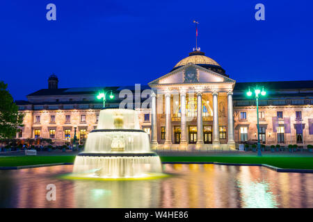 Deutschland, alten Wiesbadener Kurhaus Gebäude hinter der beleuchteten Brunnen in der blauen Stunde Stimmung Stockfoto