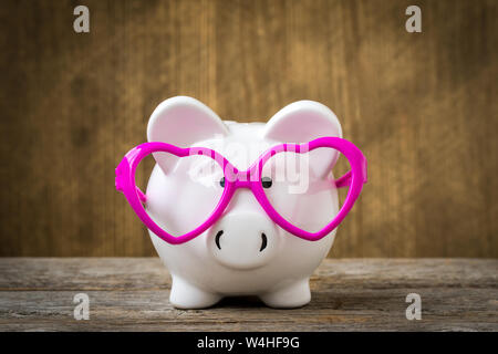 Piggy Bank trägt eine rosa Brille Stockfoto