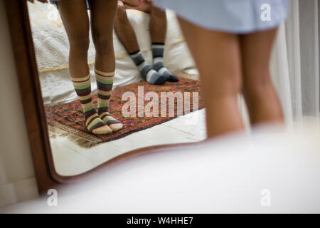 Frau, die in Socken vor ihrem Schlafzimmer Spiegel. Stockfoto