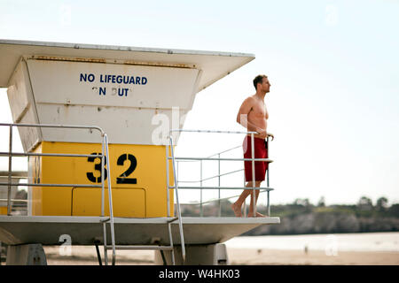 Rettungsschwimmer in lifeguard Tower überblickt den Strand. Stockfoto