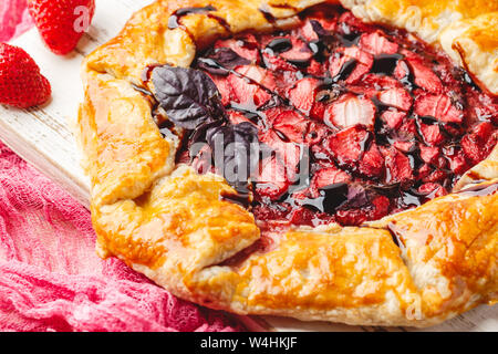 Hausgemachte Erdbeere öffnen pie Gallet mit lila Basilikum und Balsamico Dressing auf einem hellen Hintergrund. Close Up. Stockfoto