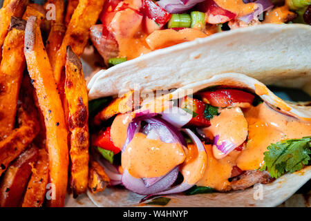 Gesunde pitta Kebabs und Kartoffel Pommes mit Zwiebeln, Paprika, Koriander und Frühlingszwiebeln in eine große Schüssel Stockfoto