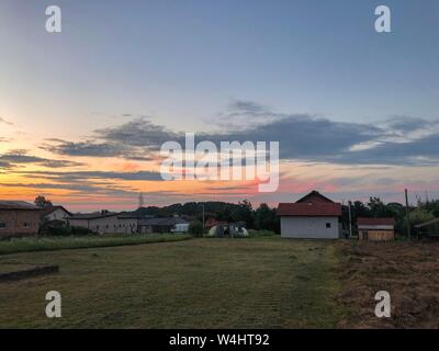 Malerische Szene eines Viertels in Bosnien an einem ruhigen Sommerabend mit einem wunderschönen Sonnenuntergang, der den Himmel färbt. Stockfoto