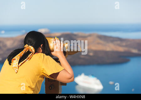 Schöne junge Frau an Kreuzfahrtschiffen mit Fernglas in Thira, Santorini, Griechenland geniessen Urlaub suchen, selektiven Fokus Stockfoto