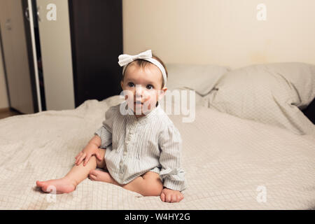 Süßes neugeborenes Mädchen auf dem Bett liegen. Das Baby will im Bett der Eltern schlafen. Stockfoto