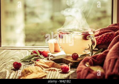 Herbst crunberry, Rosmarin und orange dampfenden Tee vor dem Fenster Stockfoto