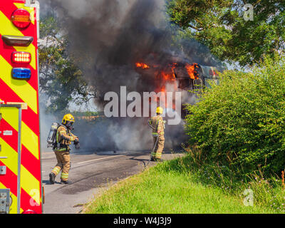 Eine Crew von Lincolnshire Feuer und Rettung Tragen von Atemschutzgeräten in Aktion an der Szene eines größeren Fahrzeugs Brand eines Mähdreschers Stockfoto