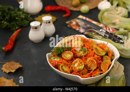 Koreanischen Stil mit grünem Salat, Tomaten und Karotten in einer weißen Schüssel Salat auf einem dunklen Hintergrund Stockfoto