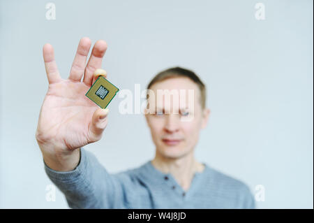 Der Prozessor ist in der Hand des Mannes. Ein Mann hält ein Prozessor zwischen zwei Fingern. Stockfoto