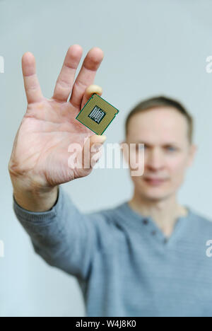 Der Prozessor ist in der Hand des Mannes. Ein Mann hält ein Prozessor zwischen zwei Fingern. Stockfoto