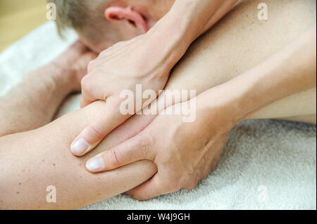 Gesundheit Massage Therapie. Weibliche Hände massieren Arm des Mannes. Stockfoto