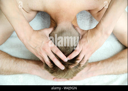 Gesundheit Massage Therapie. Weibliche Hände massieren den Kopf des Mannes. Stockfoto