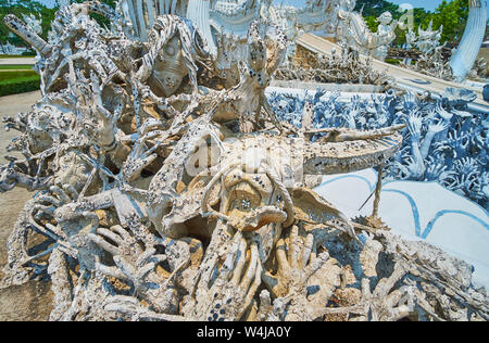 Die beängstigende Szene der Hölle und Horror vor der weiße Tempel (Wat Rong Khun), berühmt für seine einzigartige Architektur und komplizierten skulpturale decorat Stockfoto