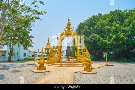 Die reich verzierten vergoldeten arch mit geschnitzten Details und feine Muster hält die Große ritual Glocke, weiße Tempel (Wat Rong Khun), Chiang Rai, Thailand Stockfoto