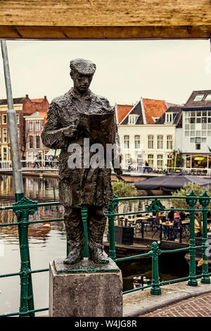 Leiden, Holland, Niederlande, April 17, 2019, Blume Verkäufer Bronze Skulptur auf der Brücke Visbrug (Fisch), Blumen, Markt, Fassaden des holländischen Häuser in Stockfoto