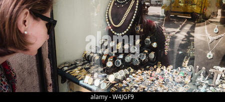 Barcelona, Spanien - Jun 1, 2018: Neugierig elegante touristische Frau am vorderen Showcase Fenster Suchen auf zentralen Juweliergeschäft in der spanischen Stadt Auswahl Ringe, Ohrringe, broches, Perlen und Diamanten Stockfoto