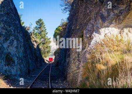 Eine Lokomotive nimmt Touristen entlang der Weka Pass Bahn durch die malerische Kalksteinfelsen und vorbei an Weinbergen aus Waipara, um Waikari in Canterbury, Stockfoto