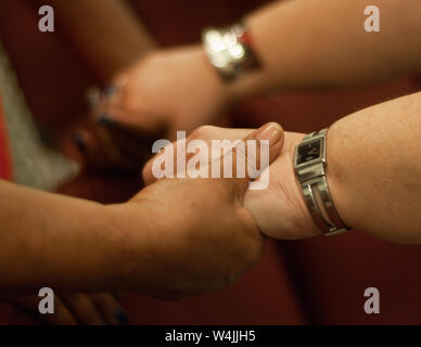 Menschen an Händen während einer Krise der Gemeinschaft Gebet service Mai 26, 2010 an der ersten Baptist-Kirche in St. Bernard Parish in Chalmette, Louisiana zu beten. Stockfoto