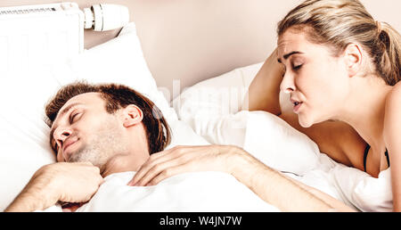 Frau kann nicht im Bett schlafen, da Schnarchen Mann schlafen neben ihr. Stockfoto