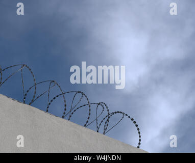 Silhouette von Concertina wire Perimeter an einer Wand Stockfoto