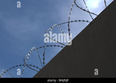 Silhouette von Concertina wire Perimeter an einer Wand Stockfoto