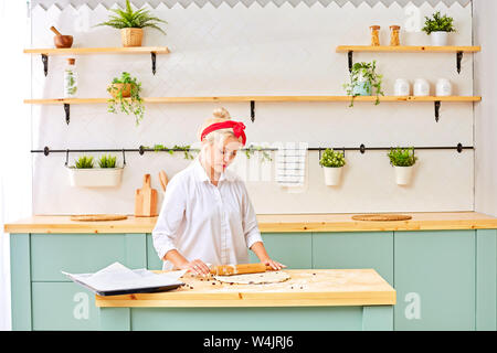 Junge Frau backen Weihnachtsplätzchen zu Hause Stockfoto