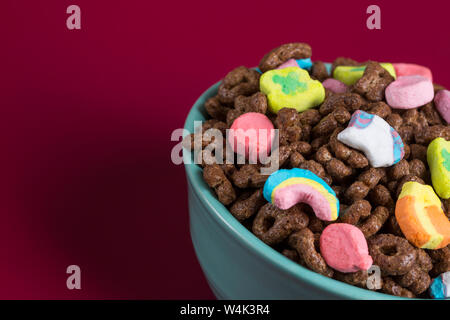 Mit Schokoladegeschmack marshmallow Müsli in eine blaue Schale auf einem Holz und Magenta Hintergrund Stockfoto