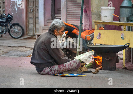 Bikaner, Indien - 11. Februar 2019: Der Mann, der Zubereitung von Speisen auf Feuer in den Markt von Bikaner. Rajasthan Stockfoto