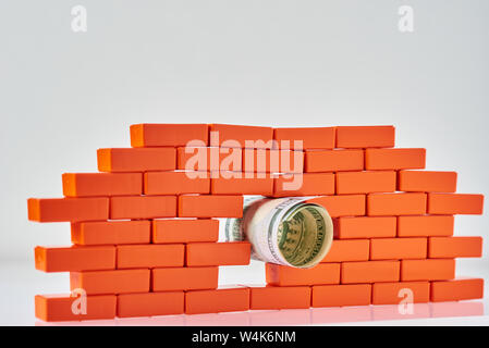 Gebrochene Mauer mit Dollar Bill in der Bohrung. Business und Finanzen concepte Stockfoto