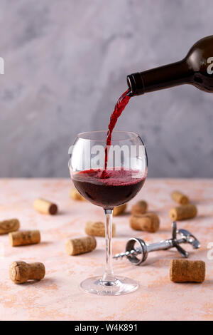 Rotwein wird in ein Glas gegossen. Das Konzept der Weinbereitung. Unter ihrem Text platzieren. Close-up. Stockfoto