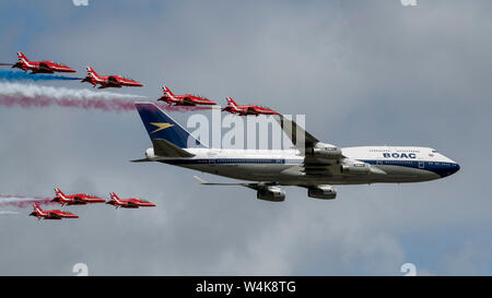 Die Royal Air Force Red Arrows und British Airways Boeing 747-436 Verhalten ein Flypast während der 2019 Royal International Air Tattoo an RAF Fairford, England, 20. Juli 2019. Dieses Jahr, RIAT gedachte der 70. Jahrestag der NATO hervorgehoben und nachhaltiges Engagement der Vereinigten Staaten bei ihrer europäischen Verbündeten. (U.S. Air Force Foto von Airman 1st Class Jennifer Zima) Stockfoto