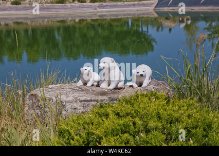 Baku Aserbaidschan - 05.07.2018. Statue von Braun Weiß Bär mit Jungtier vor rapsfeld unter einem See geschnitzt. Drei weiße Bär-cub Statue Stockfoto