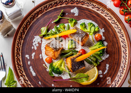 Gebackener Lachs auf Chia Sauce mit Brokkoli, Möhren, Tomaten, grüne Bohnen, horizontale Foto, Nahaufnahme, Ansicht von oben Stockfoto