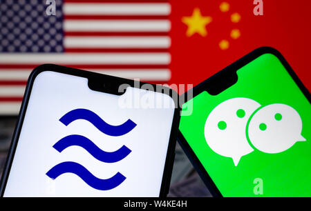 Facebook Waage und WeChat Logos auf den Smartphones und verschwommenes Flaggen der USA und China auf dem Hintergrund. Konzeptionelle Foto. Stockfoto