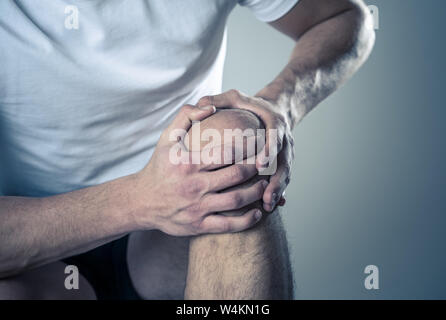 Junge passen Mann mit Knie mit den Händen der Schmerzen nach Leiden Muskelverletzung gebrochenen Knochen Schmerzen im Bein verstaucht oder Krampf beim Lauftraining. Im Körper Schmerz Stockfoto