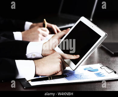 Ein Mann trifft einen digitalen Tablet, close-up auf Teamarbeit Hintergrund Stockfoto