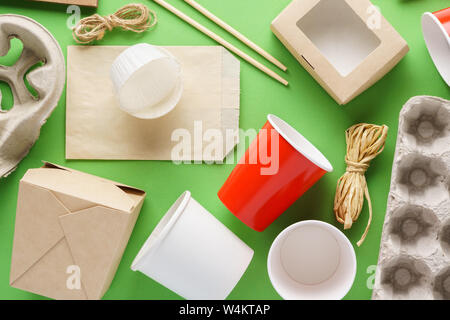 Einstellen der verschiedenen umweltfreundlichen Einwegverpackungen und Container auf grünem Hintergrund. Stockfoto